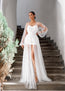 Woman in a white wedding dress standing on stone steps with greenery.